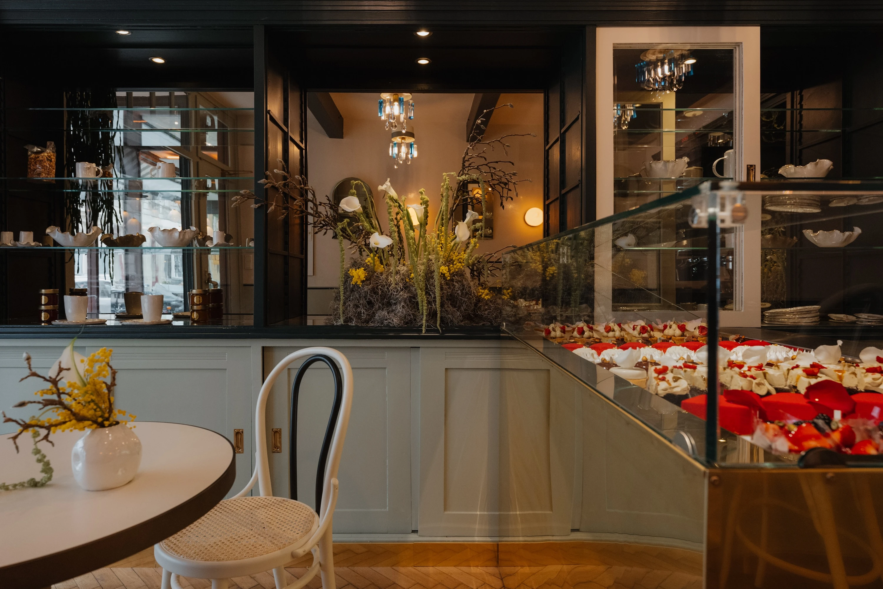 Stilvolles Café-Interieur mit Kuchen und floralen Elementen.